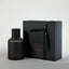 Black perfume bottle and packaging on a light gray background