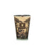 Candle with a decorative sleeve featuring tree patterns on a white background